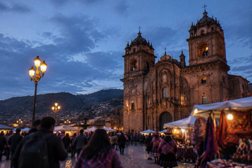 A festival crowd on a Cusco plaza with food stalls and traditional dress