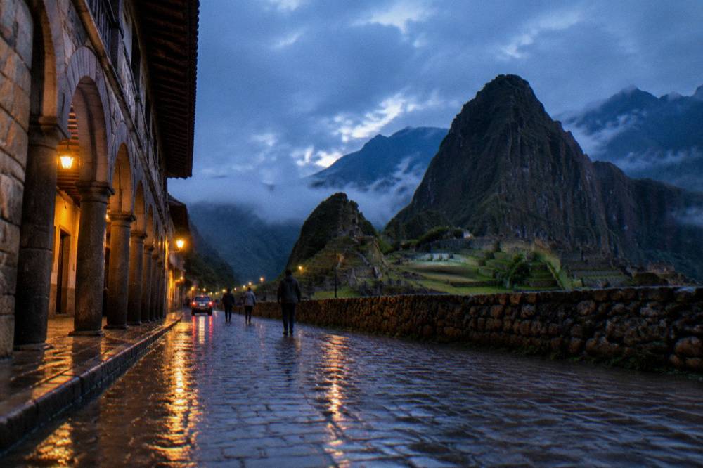 Rain-soaked Cusco street with wet cobblestones reflecting colonial arcades