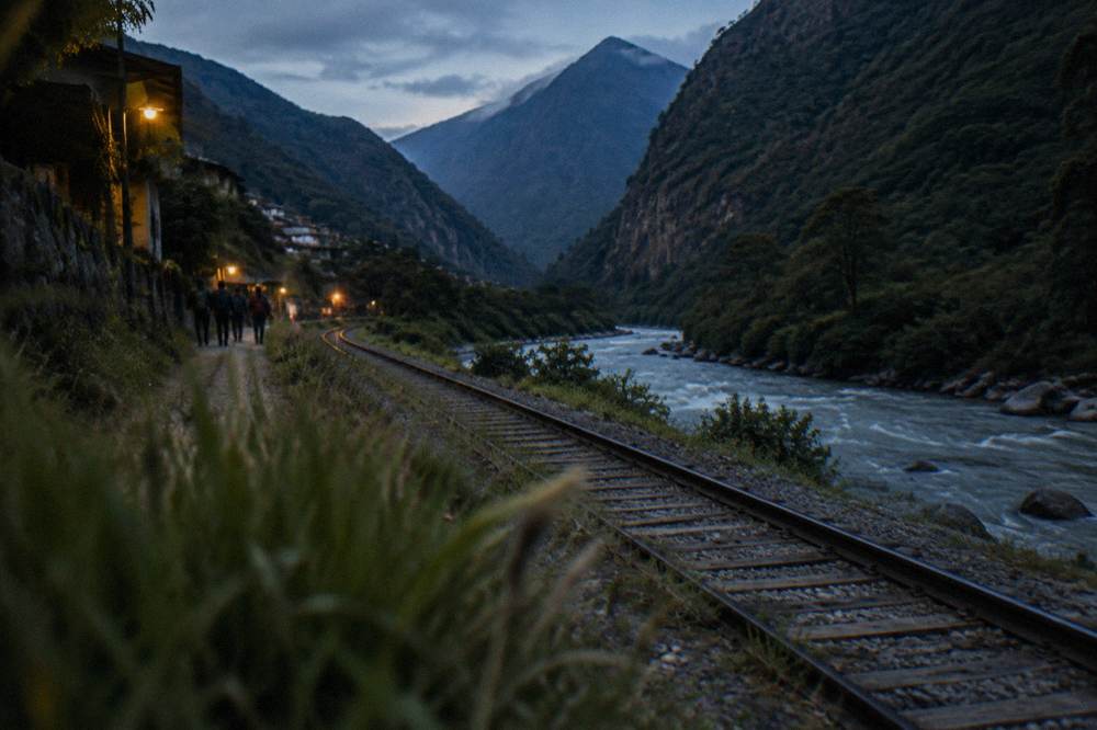 Railway track beside a river winding through steep forested mountains