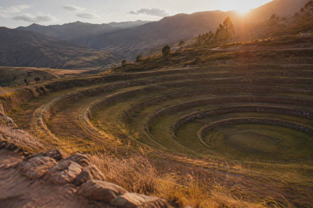Concentric terraced rings cut into an earthy plateau in the Andes