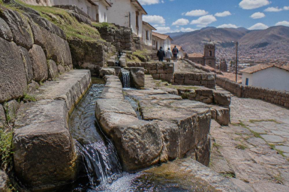 Carved stone channels carrying a stream at a small Inca water site near Cusco