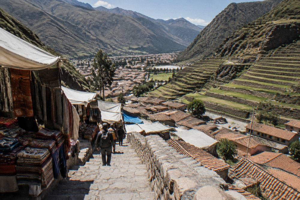 Agricultural terraces stepping down a valley hillside with a village below