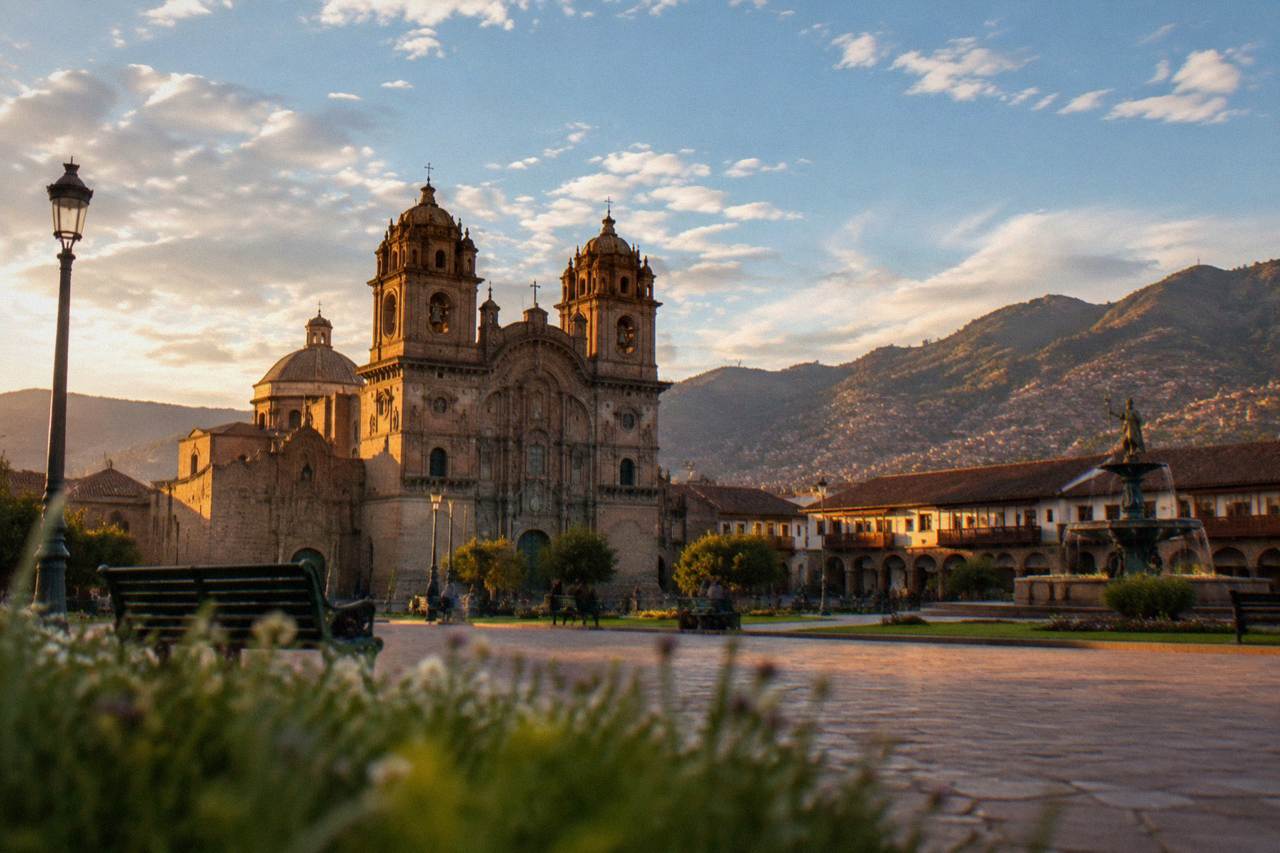 The Plaza de Armas in Cusco with the cathedral and stone arcades under a wide sky