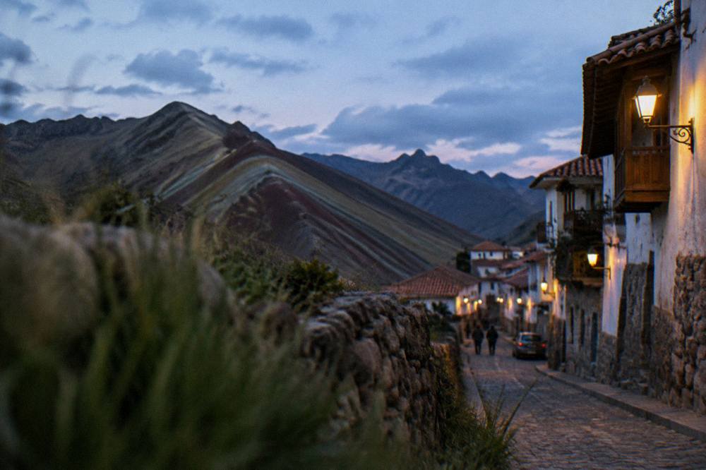 A narrow colonial street in Cusco rising toward San Blas with stone walls and balconies