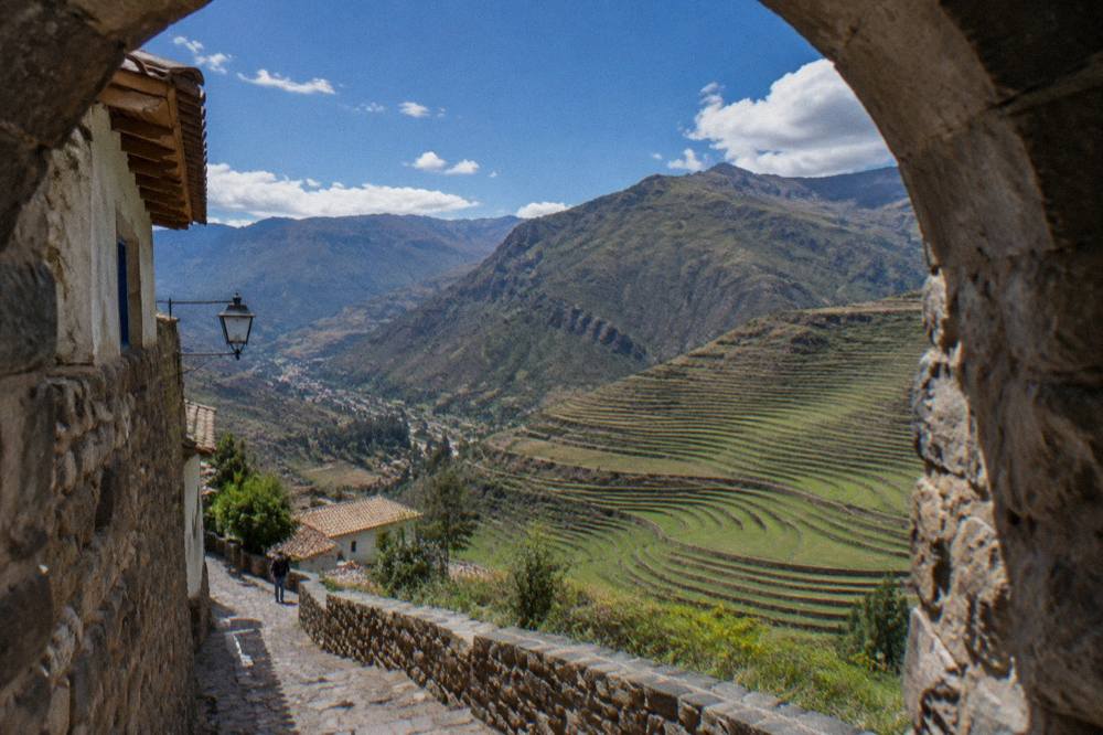 Green agricultural terraces curving down a valley slope near Pisac