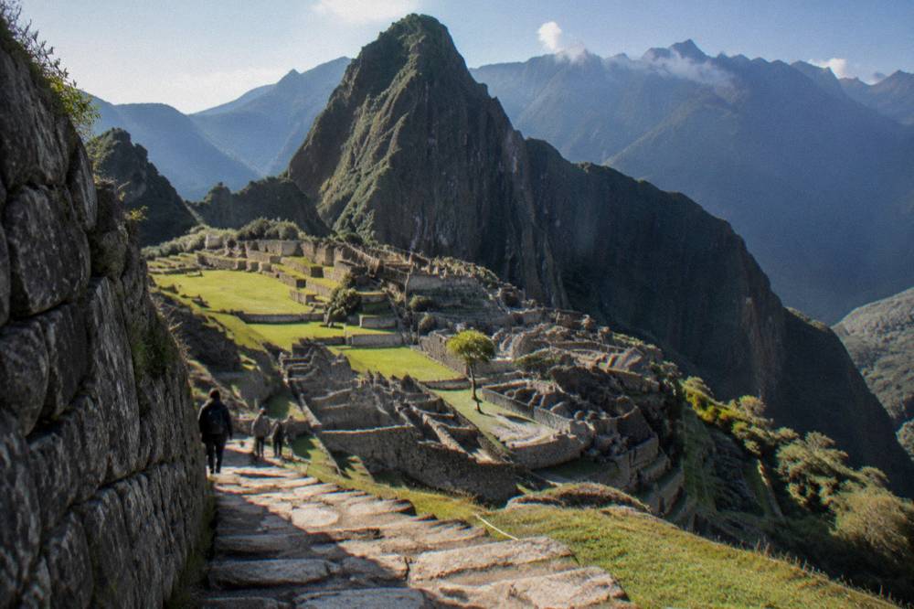 Terraced stone terraces of Machu Picchu with the green peak of Huayna Picchu rising behind