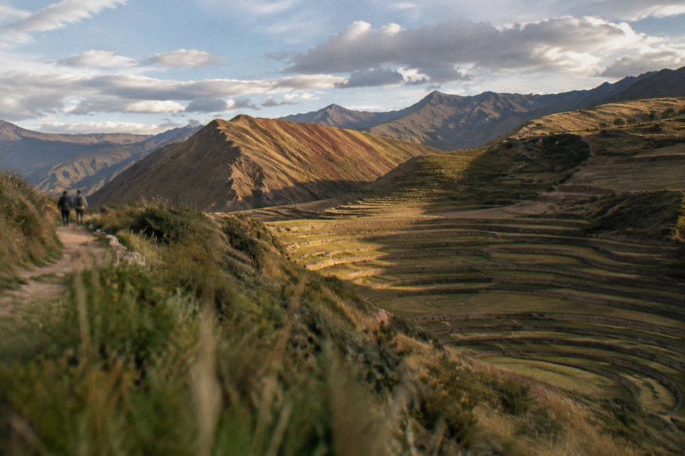 Striped mineral bands of red and ochre on a high Andean ridge under scattered cloud