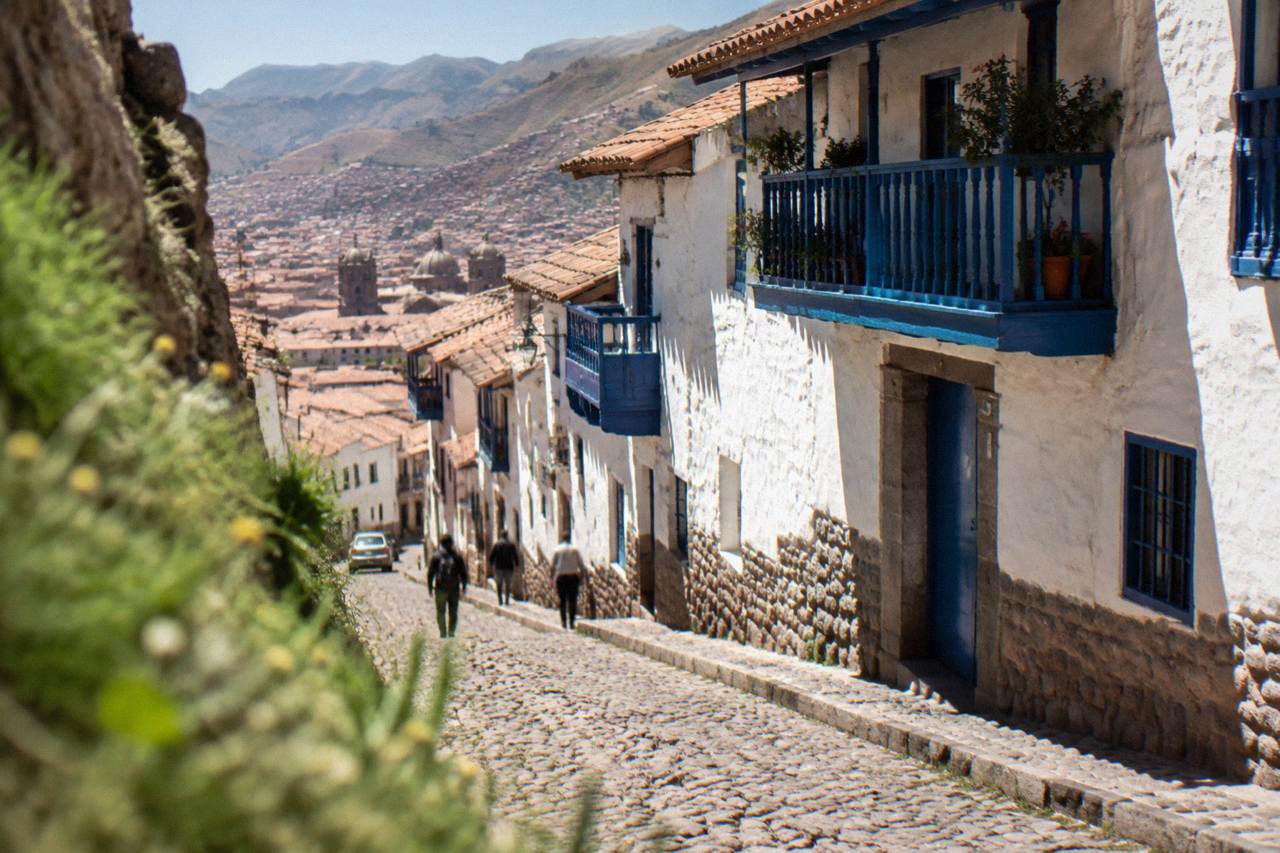 The Plaza de Armas in Cusco with colonial arcades and hills rising behind the city