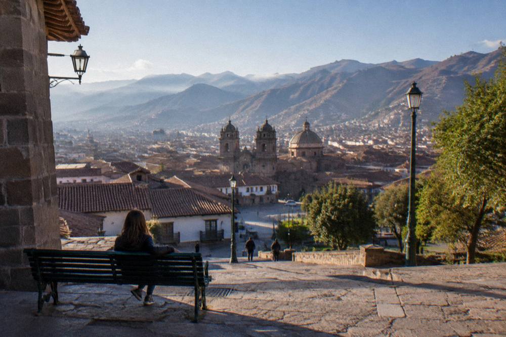 A traveller resting on a bench overlooking Cusco's tiled rooftops