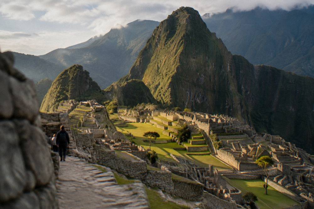 Terraced stone ruins of Machu Picchu with a green peak rising behind