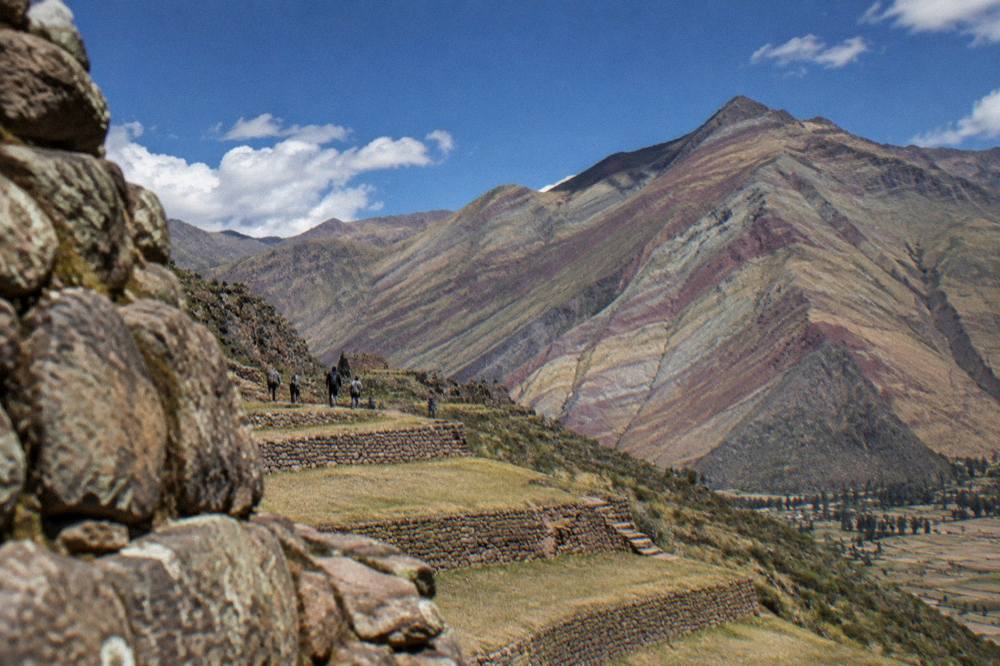 Striped mineral slopes of a high Andean mountain under a blue sky