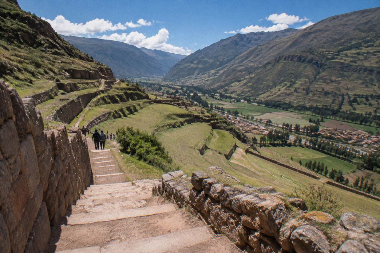 Terraced Andean hillsides above a Sacred Valley town with fields and mountains in the distance