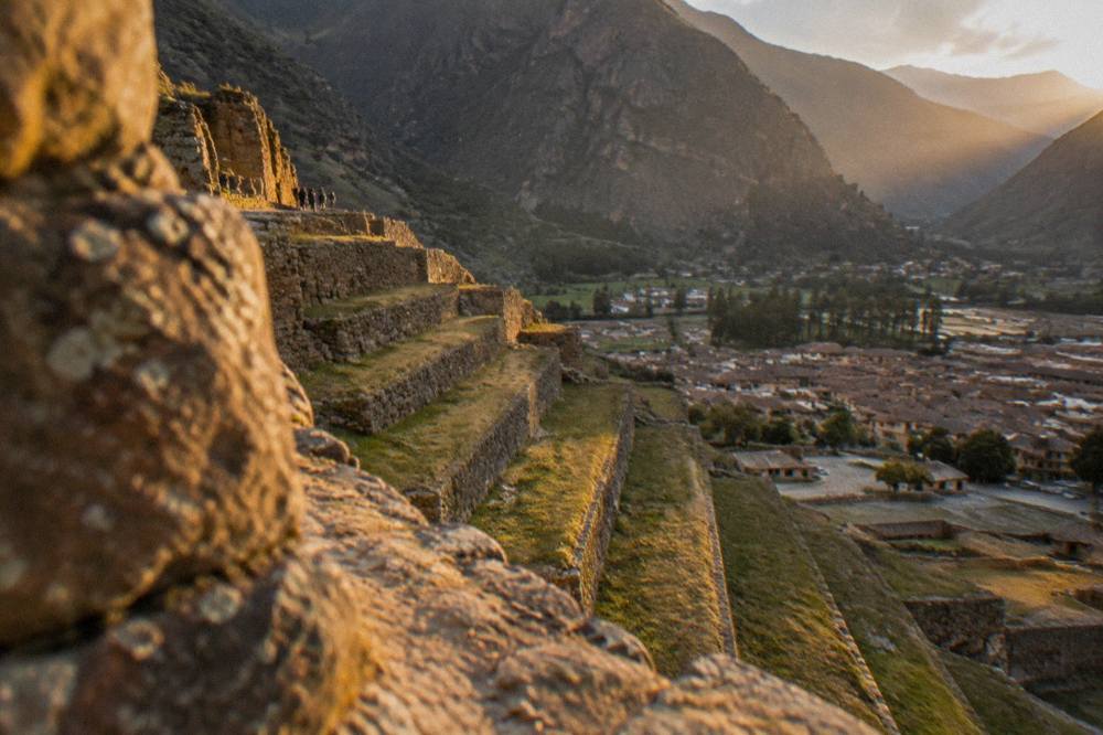 Inca agricultural terraces cut into a hillside with a small town below