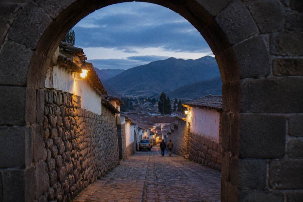 A stone Inca doorway and narrow walled street in an old Andean town
