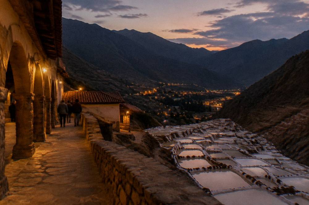 A valley town at dusk with lights coming on below dark ridgelines